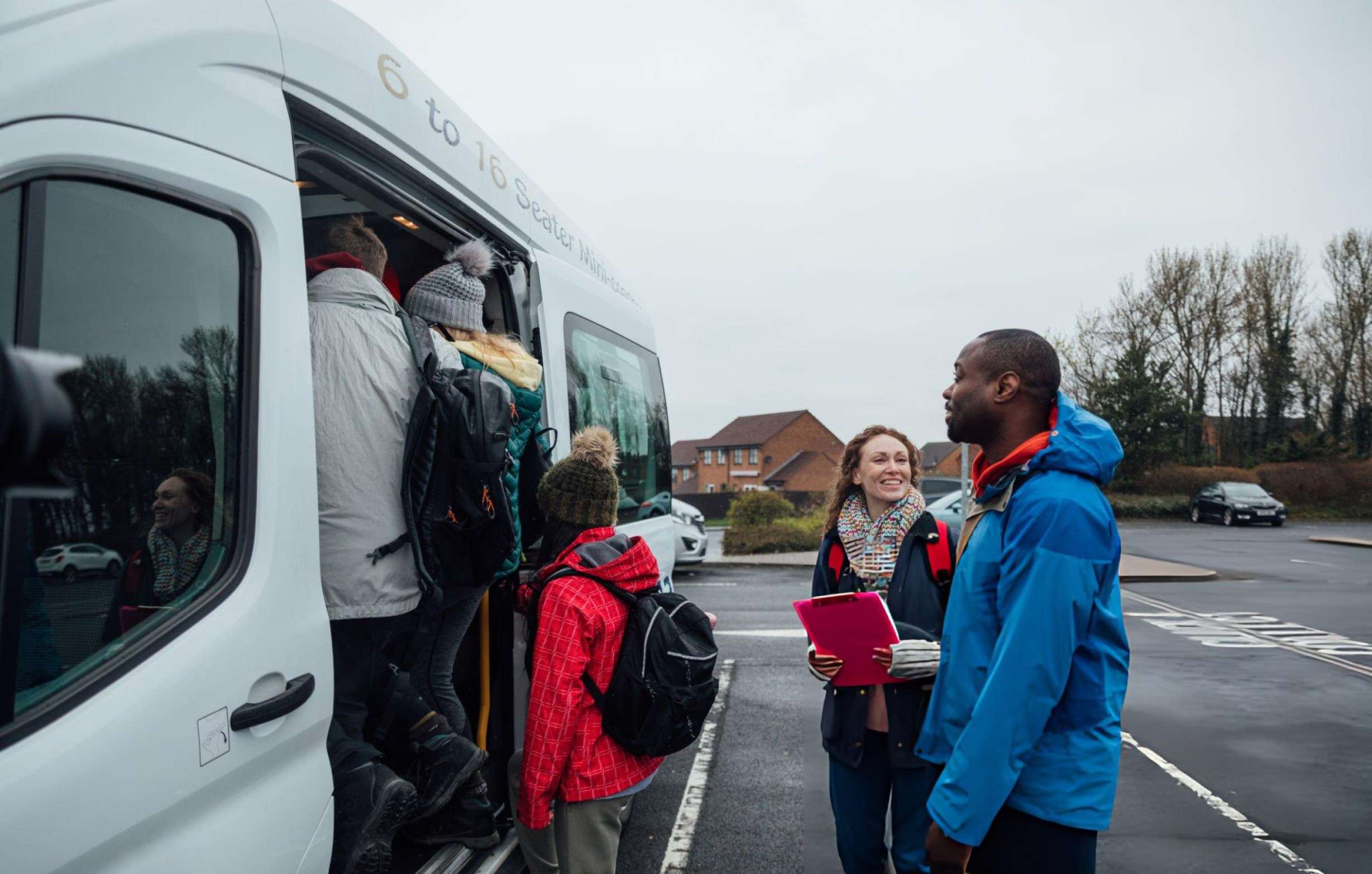 a group of happy people boarding a shuttle van